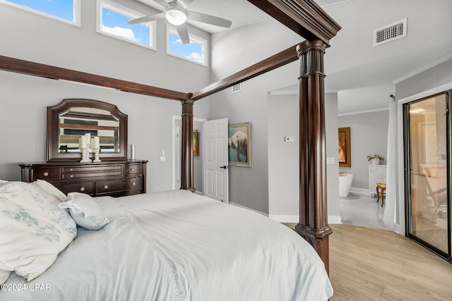 bedroom with connected bathroom, ornamental molding, decorative columns, and light hardwood / wood-style floors