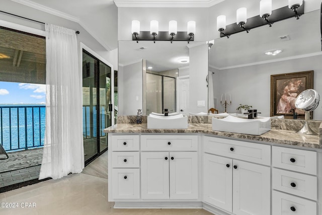 bathroom featuring vanity, crown molding, a shower with shower door, and a water view