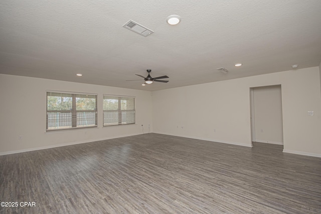 spare room featuring ceiling fan, dark wood-type flooring, and a textured ceiling