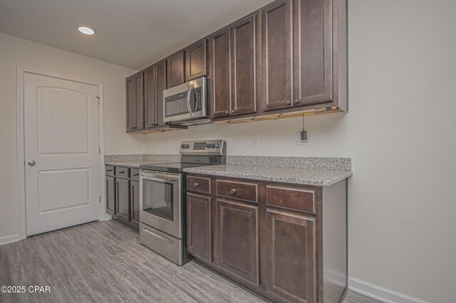 kitchen featuring dark brown cabinetry, stainless steel appliances, and light hardwood / wood-style flooring