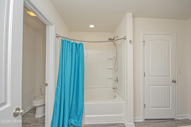 bathroom with hardwood / wood-style floors, a textured ceiling, toilet, and shower / bath combo with shower curtain