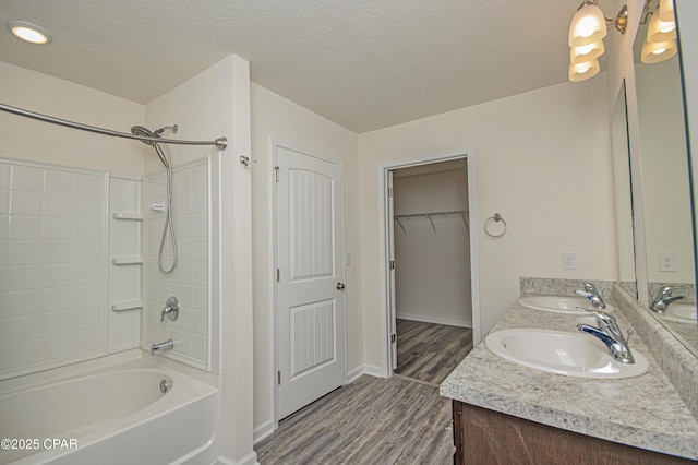 bathroom with vanity, wood-type flooring, shower / bathing tub combination, and a textured ceiling