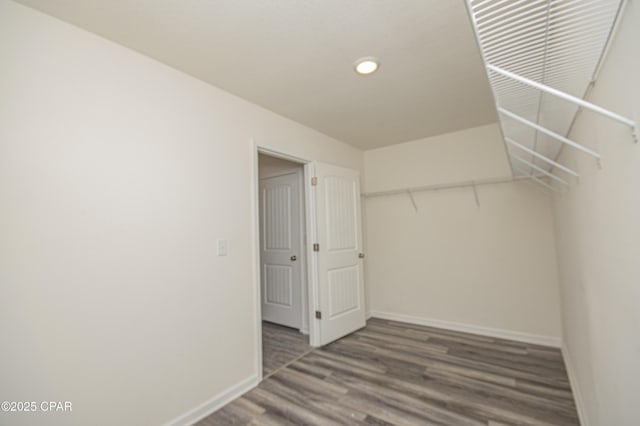 walk in closet with dark hardwood / wood-style floors