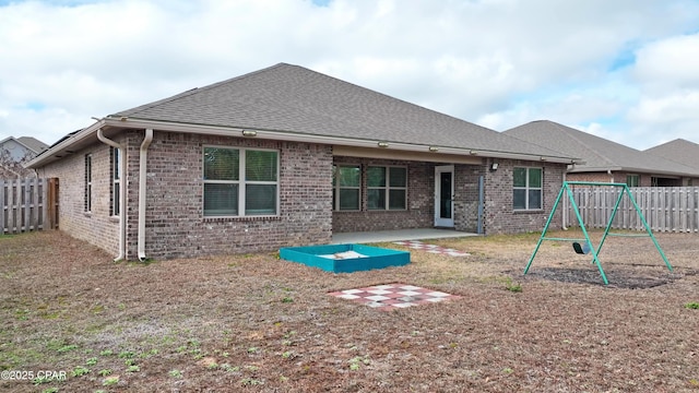 rear view of house featuring a playground and a patio area