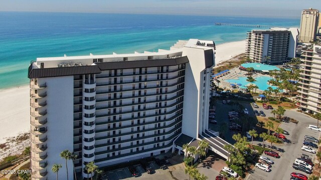 birds eye view of property featuring a water view and a beach view