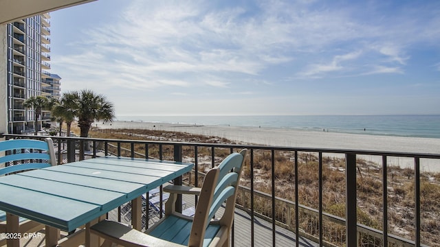 balcony featuring a view of the beach and a water view