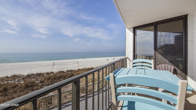 balcony with a water view and a view of the beach