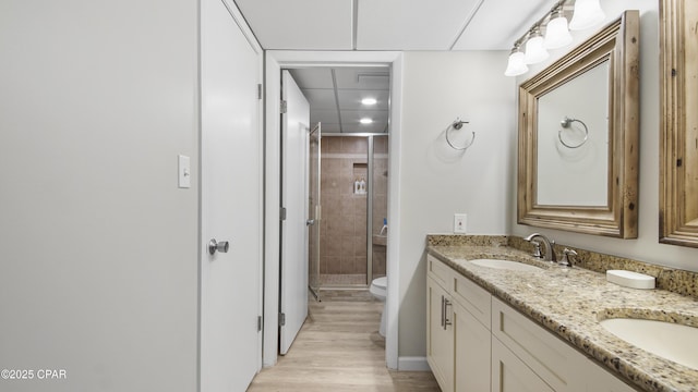 bathroom featuring vanity, hardwood / wood-style flooring, a shower with door, and toilet