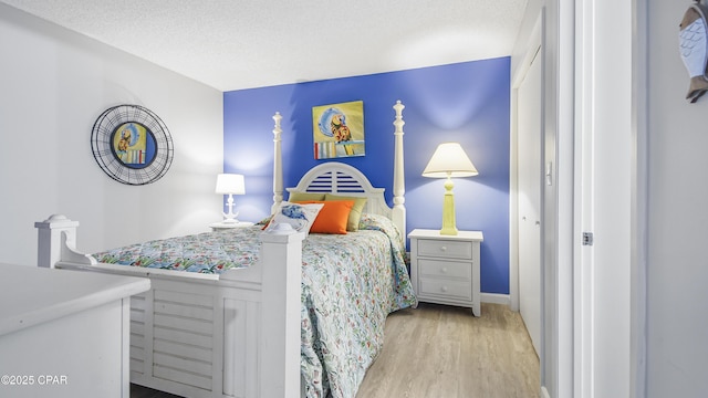 bedroom with light hardwood / wood-style flooring and a textured ceiling