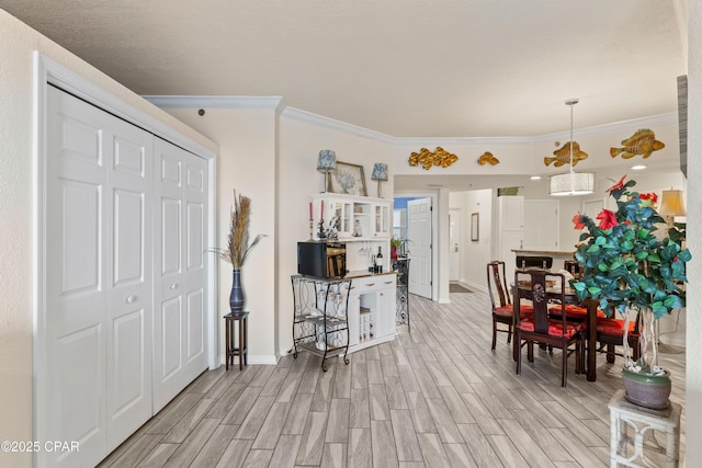 foyer with wood tiled floor, ornamental molding, and baseboards