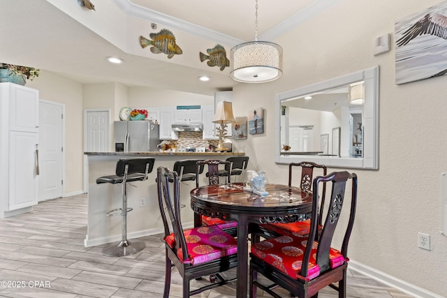 dining area featuring wood tiled floor, ornamental molding, baseboards, and recessed lighting