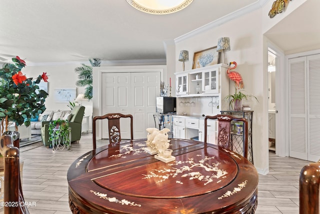 dining space with wood tiled floor and crown molding