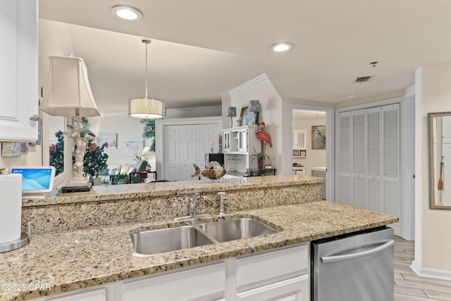 kitchen with stainless steel dishwasher, a sink, light stone counters, and white cabinetry