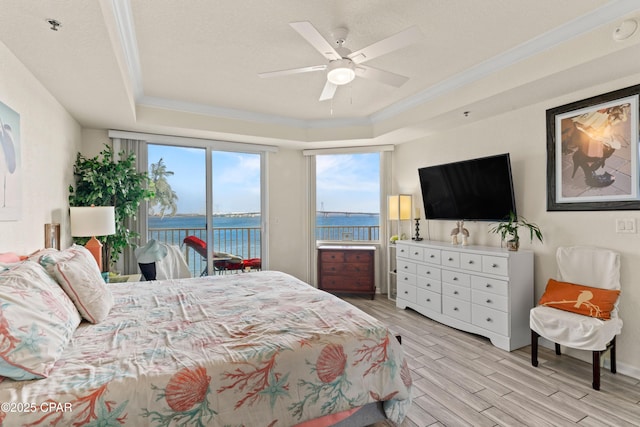 bedroom featuring ceiling fan, access to exterior, light wood-type flooring, a raised ceiling, and crown molding