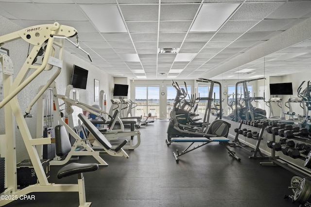 exercise room with a drop ceiling and visible vents