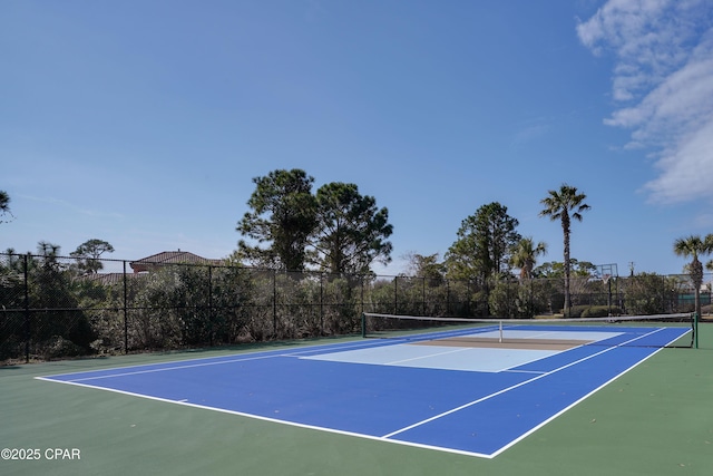 view of tennis court with community basketball court and fence