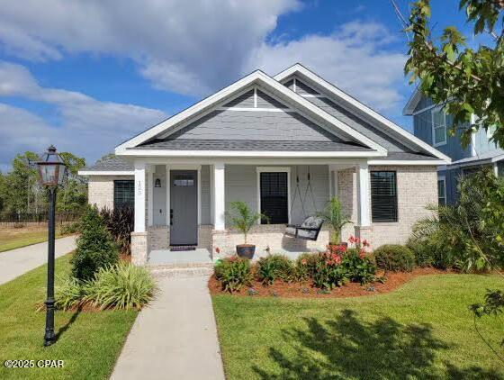 craftsman inspired home featuring a porch and a front lawn