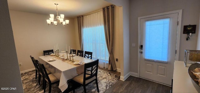 dining room featuring a healthy amount of sunlight, dark wood-type flooring, and a chandelier