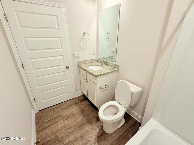 full bathroom featuring vanity, shower / bathing tub combination, hardwood / wood-style flooring, and toilet