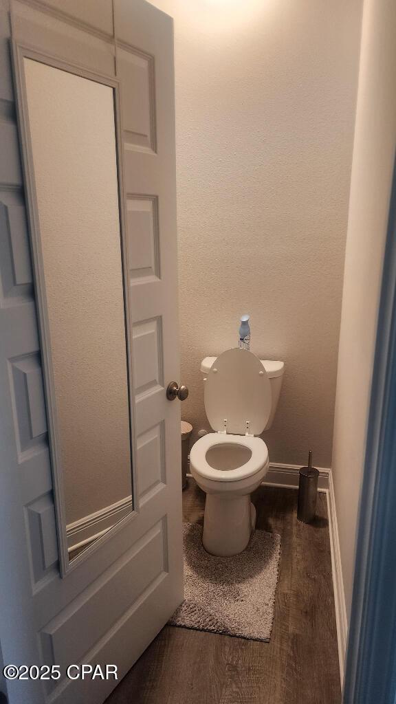 bathroom with hardwood / wood-style flooring and toilet