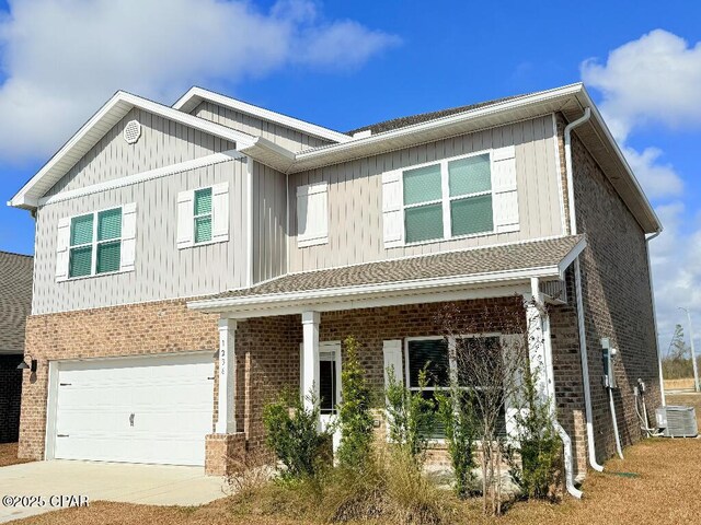 exterior space with a yard, a garage, and central AC