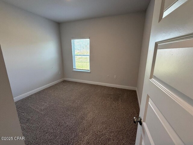 empty room featuring carpet floors and baseboards