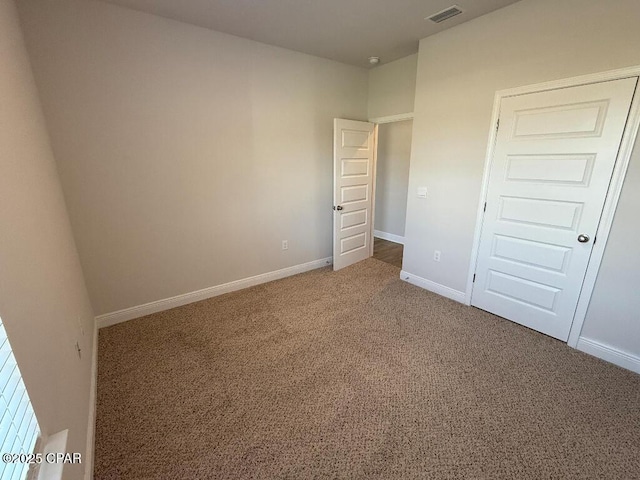 unfurnished bedroom featuring carpet floors, baseboards, and visible vents