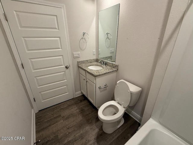 bathroom with toilet, baseboards, wood finished floors, and vanity