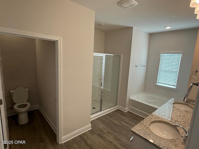 bathroom with toilet, a stall shower, visible vents, and a sink