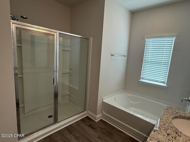 full bathroom with a bath, a shower stall, wood finished floors, and vanity