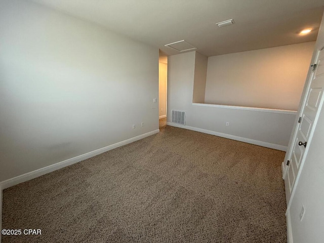 unfurnished room with carpet, attic access, visible vents, and baseboards