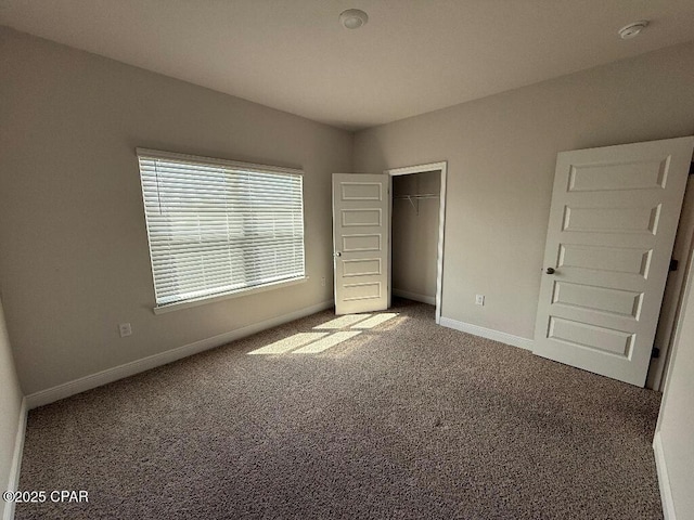 unfurnished bedroom with a closet, carpet, and baseboards