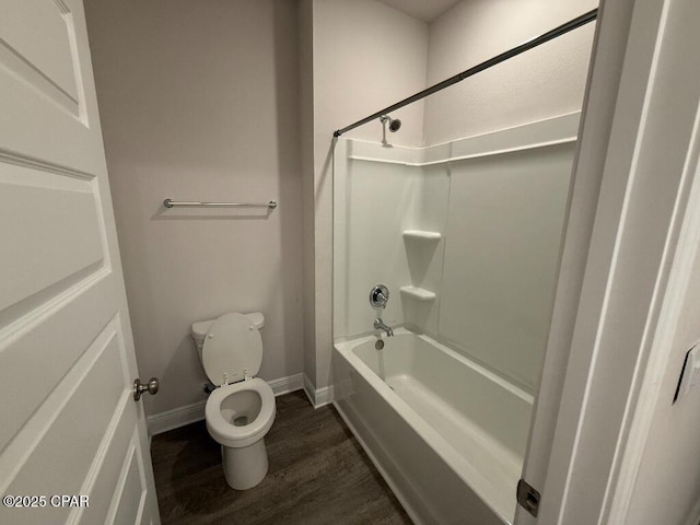 bathroom with shower / washtub combination, baseboards, toilet, and wood finished floors