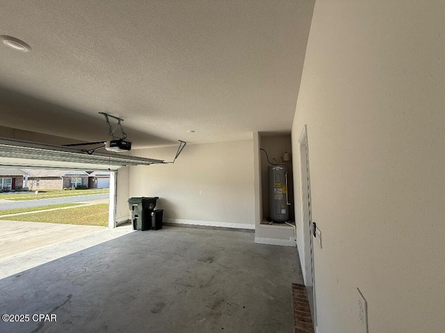 garage featuring a garage door opener, electric water heater, and baseboards