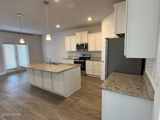 kitchen featuring appliances with stainless steel finishes, sink, hanging light fixtures, and white cabinets