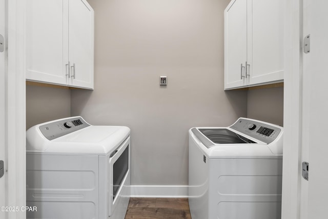 clothes washing area featuring cabinet space, washing machine and dryer, baseboards, and dark wood-style flooring