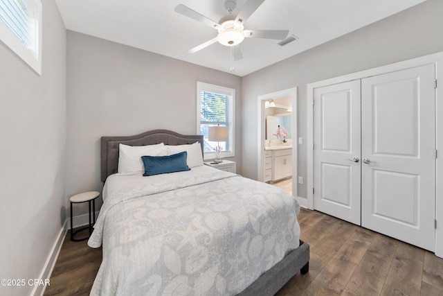 bedroom with a closet, dark wood-style flooring, visible vents, and baseboards