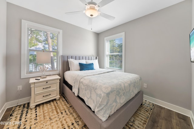 bedroom featuring ceiling fan, light wood-style flooring, and baseboards