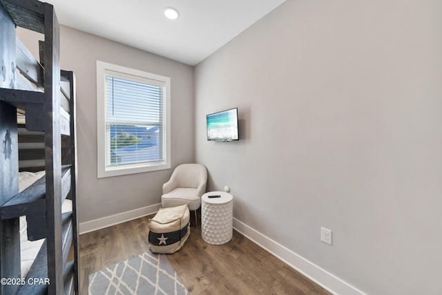 sitting room with baseboards and wood finished floors