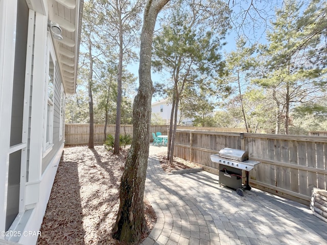 wooden deck featuring a fenced backyard, a patio, and grilling area