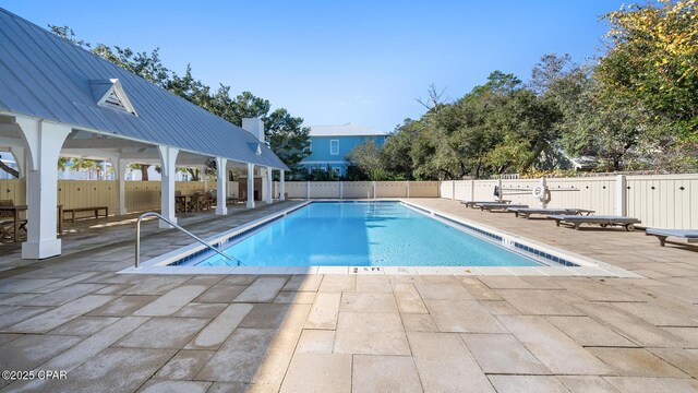 pool with a patio area and fence