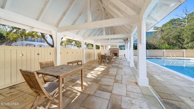 view of patio with outdoor dining space, a fenced backyard, and a fenced in pool