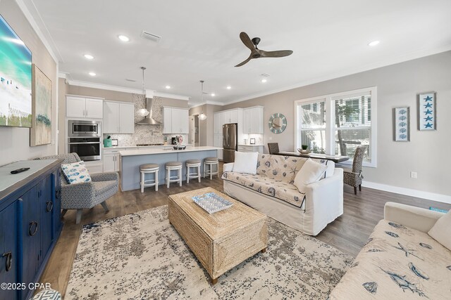 living room featuring dark wood-style floors, visible vents, and ornamental molding