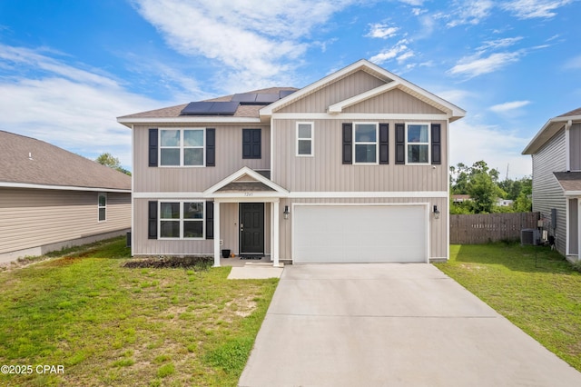 view of front of house featuring a garage, cooling unit, a front yard, and solar panels