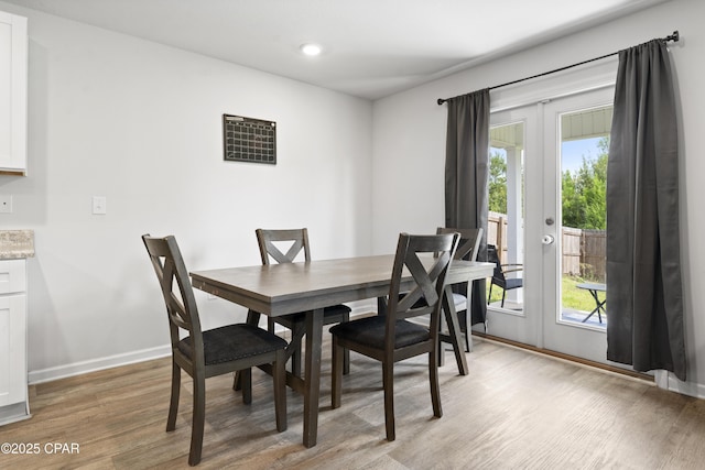 dining space with french doors and light wood-type flooring