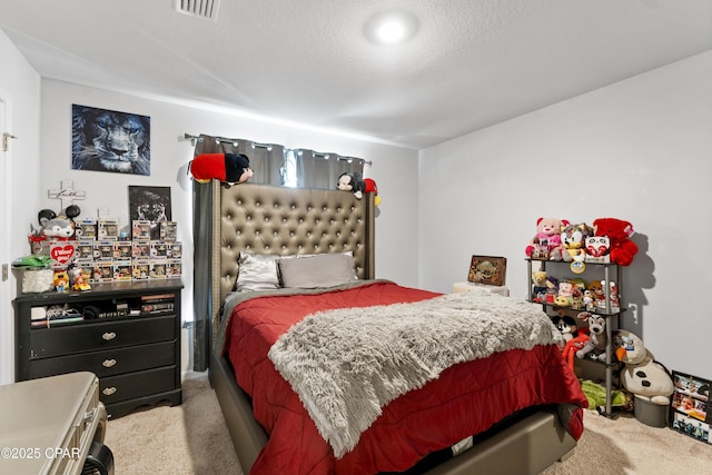 bedroom featuring light carpet and a textured ceiling