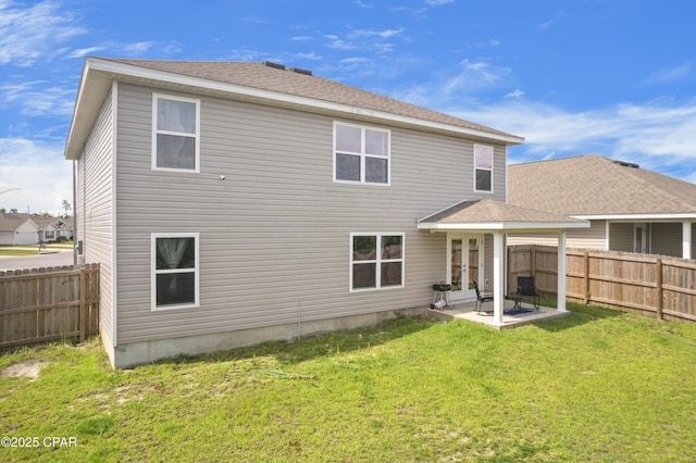 back of house with french doors, a patio, and a lawn