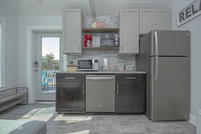 kitchen with stainless steel appliances, white cabinets, and decorative backsplash