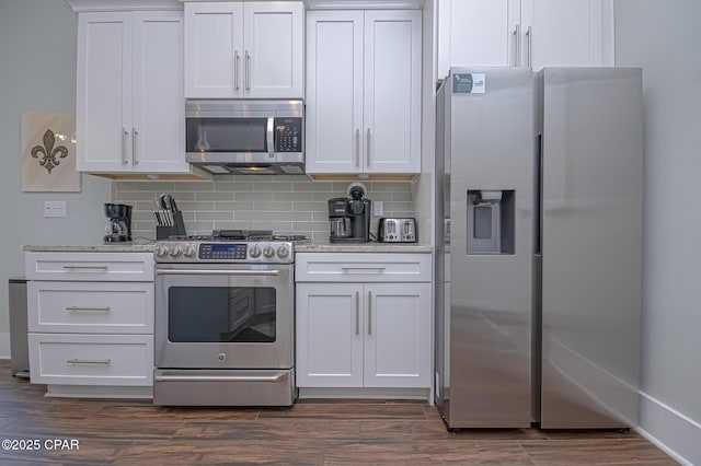 kitchen with backsplash, stainless steel appliances, and white cabinets