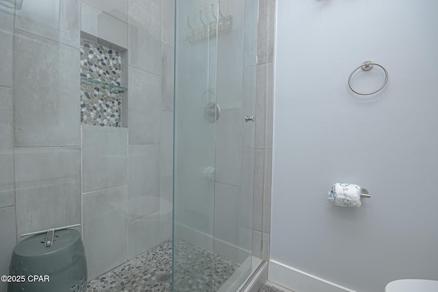 bathroom featuring tiled shower and toilet